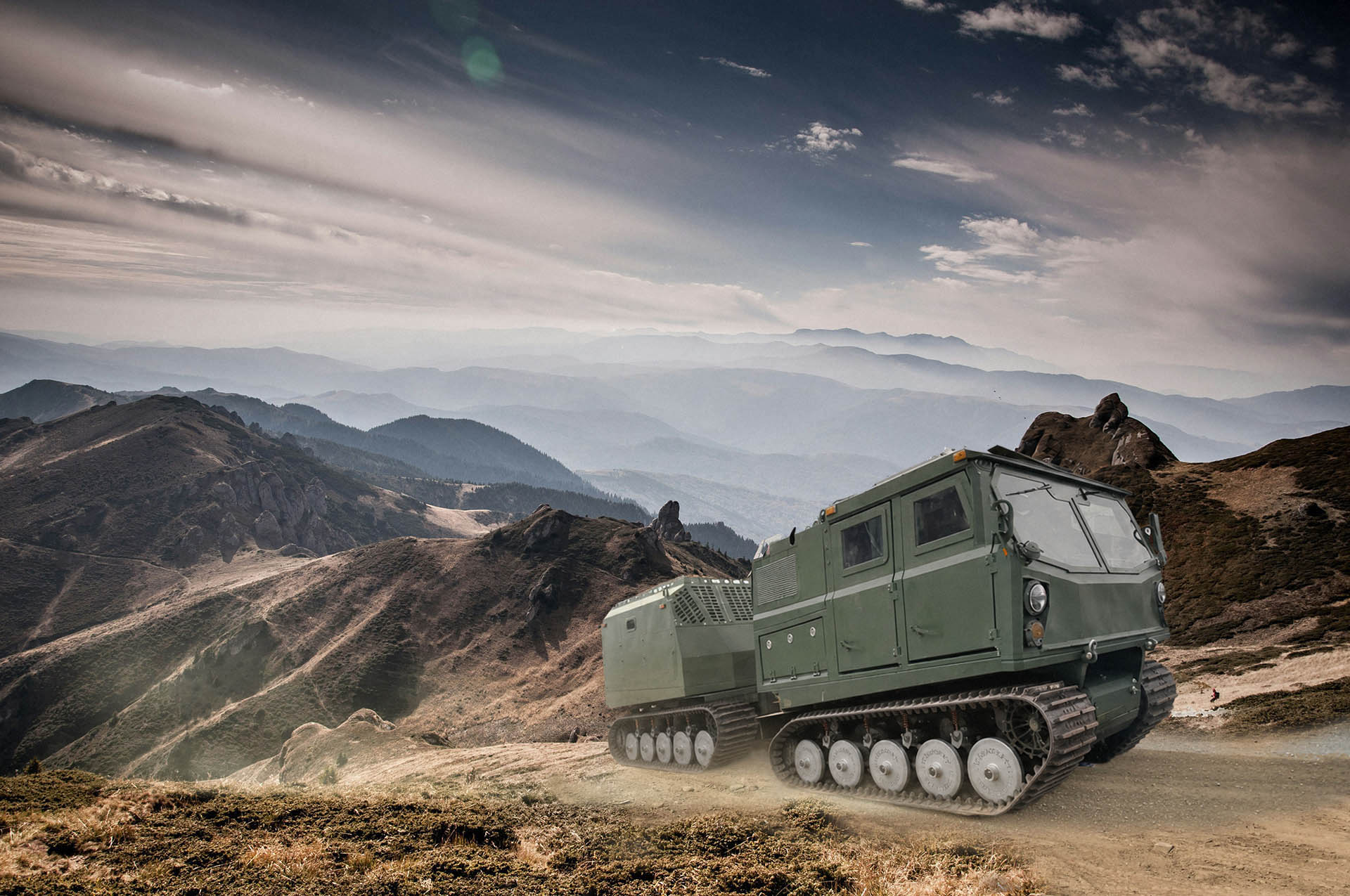 Voyager carrier on a high mountain ridge with layered blue mountain ranges in the background
