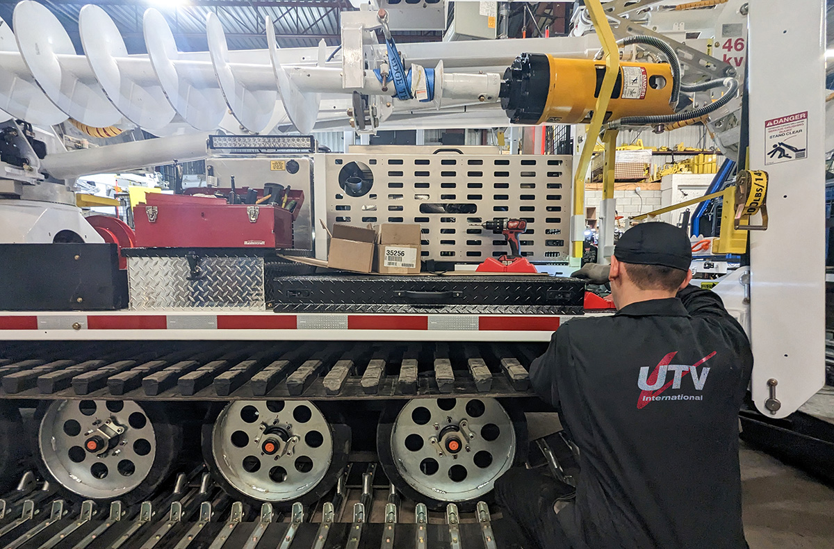 UTV International technician working on a tracked carrier in the Montréal workshop
