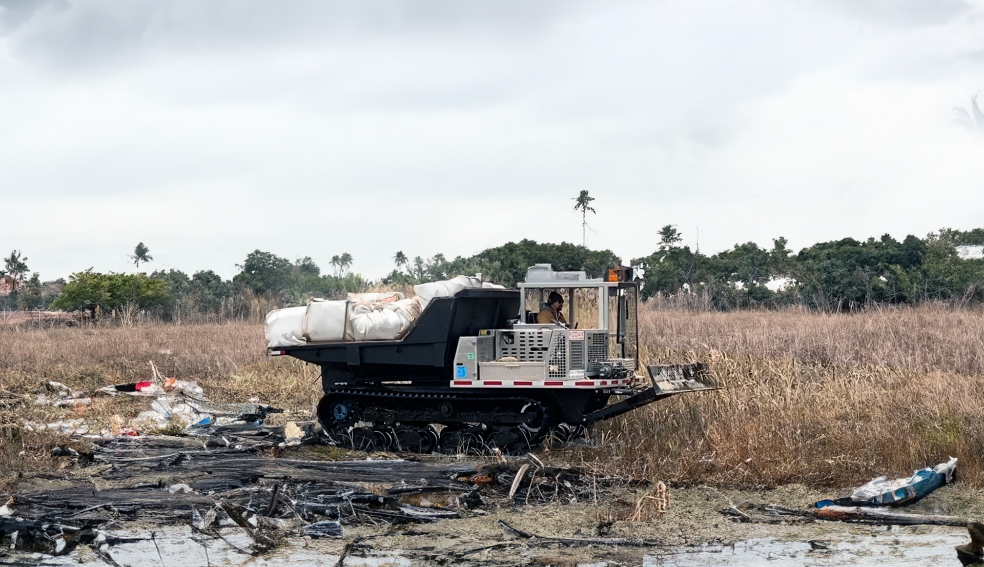 UTV Kodiak crawler carrier moving supplies across post-disaster debris field